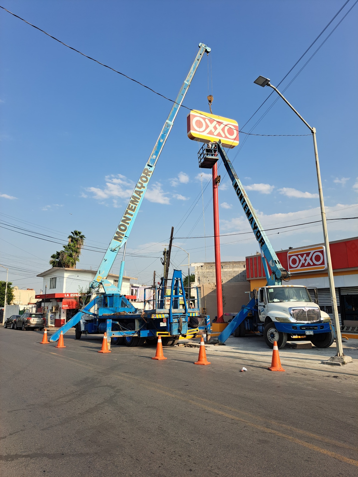Dos grúas Montemayor instalando señalización de OXXO